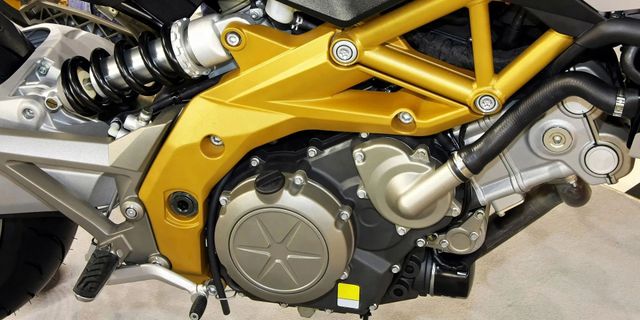 Close-up of a motorcycle engine with a gold frame and black components